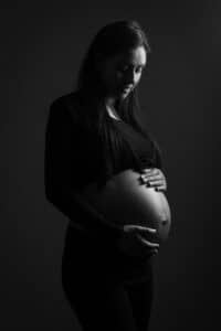 Portrait de grossesse intimiste SL-Photographie d'une future maman en chemise éclairée de façon dramatique, en noir et blanc